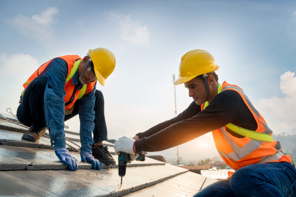 Experts Performing Repair and Replacement Services On A Roof