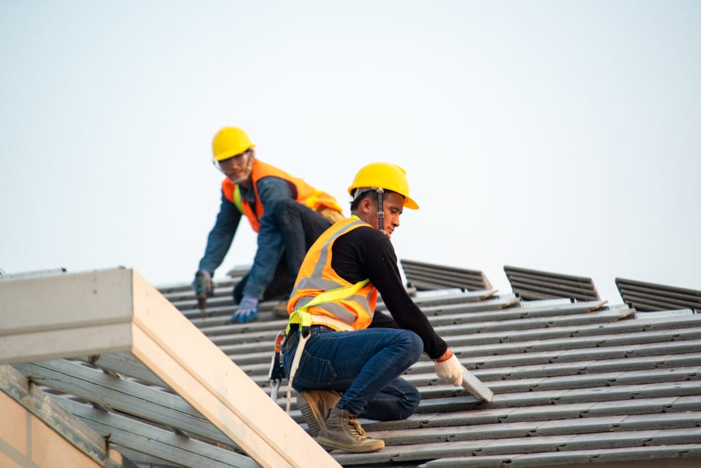 Two Workers Providing Roof Repair And Replacement Services