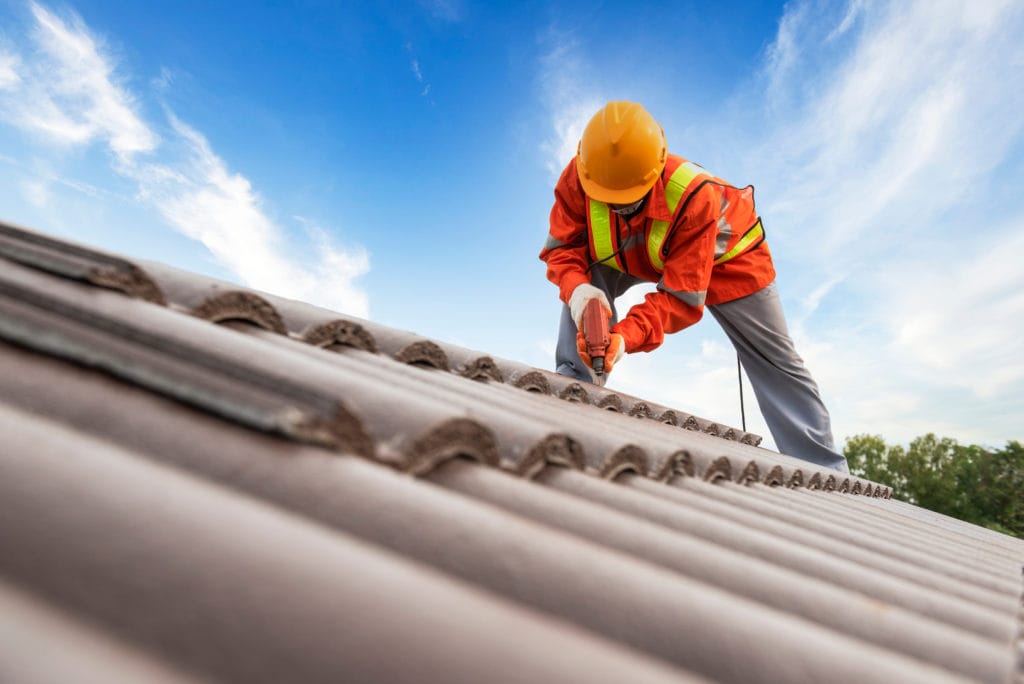 A Worker Performing Repair Services On A Roof